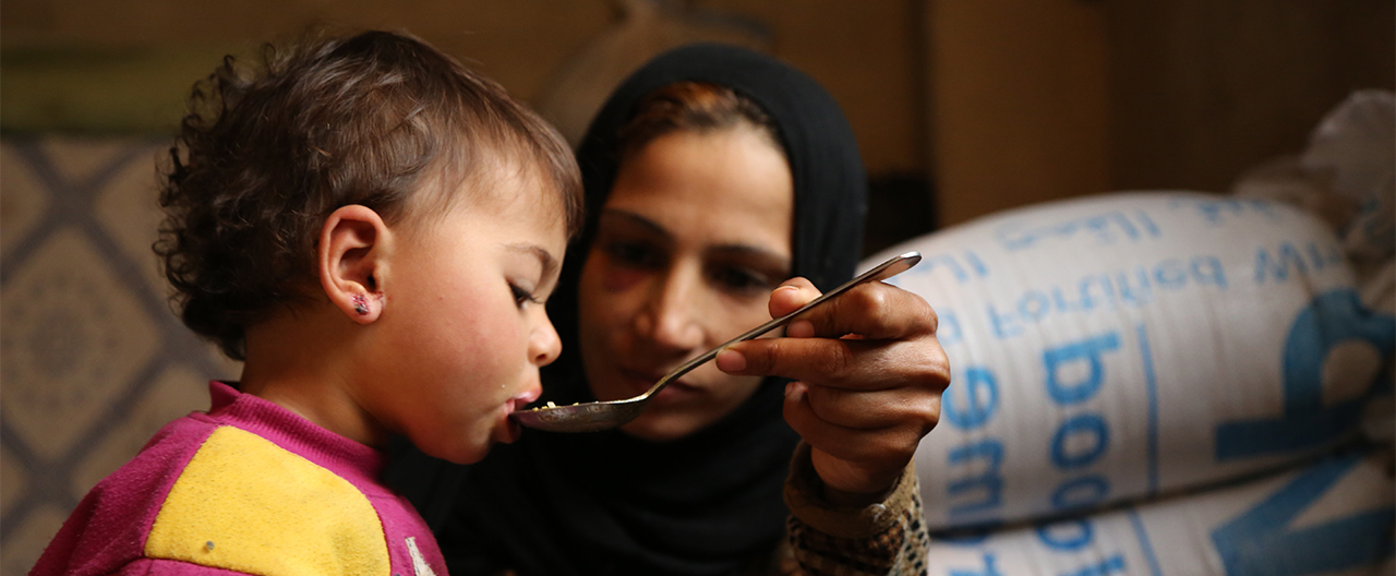 Ein syrisches Kind welches von seiner Mutter gefüttert wird.