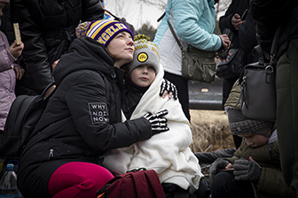 A woman and child from Ukraine embrace on the border with Poland