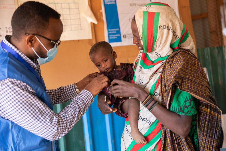 Auf diesem Foto unterhält sich ein WFP-Mitarbeiter mit Mido und ihrer jüngsten Tochter Fatun in der vom WFP finanzierten Klinik für Mangelernährung in Kabasa, Dolow. © WFP/Samantha Reinders