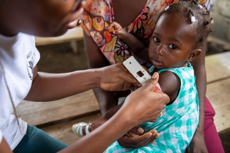 Ein junges Mädchen in Haiti wird auf akute Mangelernährung getestet, indem der Umfang ihres Oberarms gemessen wird © WFP/Theresa Piorr