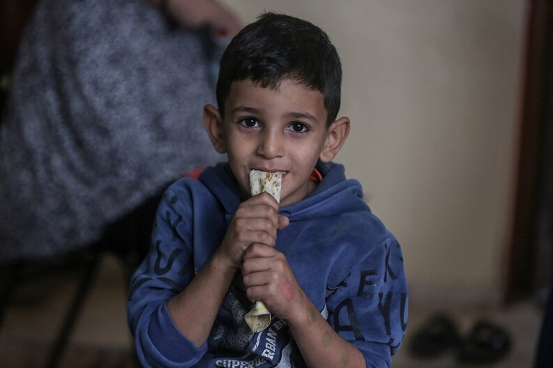 Ein kleiner Junge, einer der Söhne von Khitam, isst das von WFP bereitgestellte Brot © WFP/Ali Jadallah