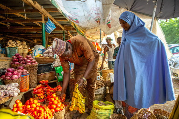 WFP/Arete/Adetona Omokanye, Frauen kaufen Tomaten auf dem Yankaaba Markt in Kano, Nigeria am 11. April 2021. Viele Menschen in Nigeria haben aufgrund der rasant steigenden Nahrungsmittelpreise Schwierigkeiten, ihre Familien zu ernähren.
