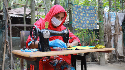 Während der Covid-19-Pandemie stellte WFP in Cox's Bazar, Bangladesch, im Rahmen seines Programms zur Sicherung des Lebensunterhalts gemeinsam mit Frauen aus der Aufnahmegesellschaft und Rohingya-Flüchtlingen Masken her, die von der örtlichen Regierung und humanitären Organisationen verteilt wurden. Sie erhielten ein monatliche Gehalt, eine Ausbildung in marktfähigen Berufen und finanziellem Wissen sowie ein Stipendium zur Gründung eines Unternehmens. WFP/Nalifa Mehelin