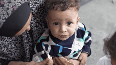 Eine Mutter in Palästina hält ihr Kind in den Armen.