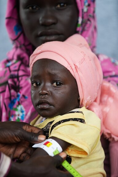 Hamida Badiru, eine 20-jährige Mutter von zwei Kindern und Flüchtling aus Kurmuk, Sudan, bringt ihre unterernährte zweijährige Tochter Entizar Zekriya zu einer Ernährungsuntersuchung in einen Gesundheitsposten im Ura-Flüchtlingslager in der äthiopischen Region Benishangul-Gumuz.