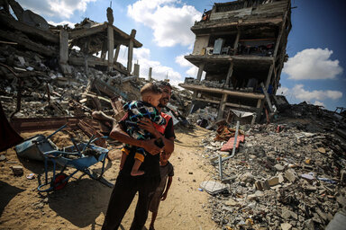 Mann mit Kind in zerstörtem Gazastreifen 