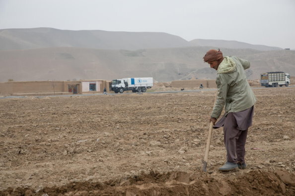 Foto: WFP/Julian Frank, Menschen in der Landwirtschaft in der Provinz Balkh mit einem WFP-Konvoi im Hintergrund