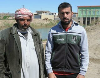 Mitib Ibrahim (L) und Mohammed Jama'a (R) stammen aus verschiedenen Stämmen und lernten sich bei der gemeinsamen Arbeit an der Instandsetzung eines Bewässerungskanals in Ramadi kennen. Foto: WFP/David Orr 