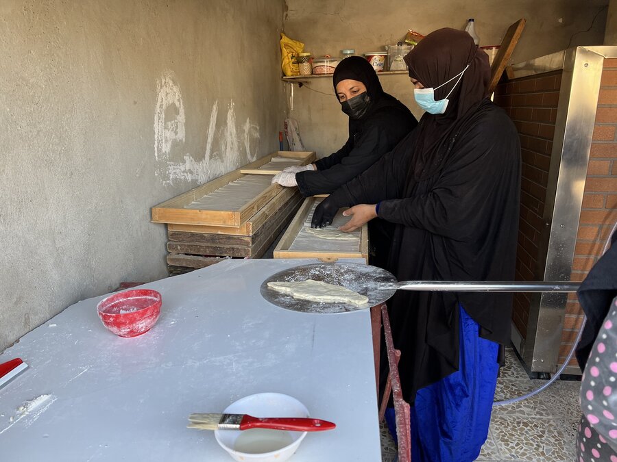 Two women prepare traditional Iraqi bread in a bakery