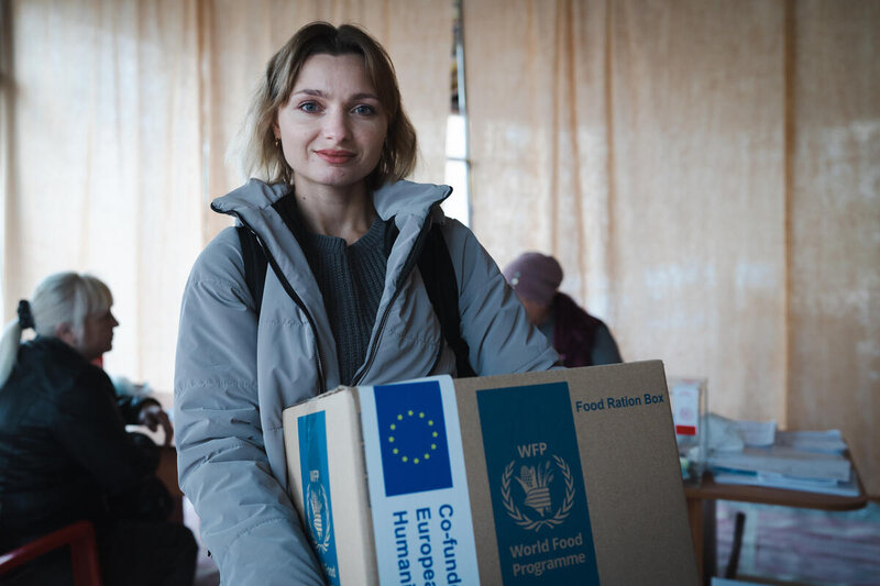 A Ukrainian woman receives a WFP food-ration box 
