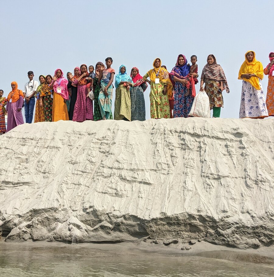 Frauen stehen in Bangladesch auf einer Sandbank