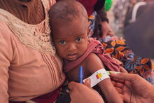 WFP/Tsiory Ny Aina Andriantsoarana, Messung des Armumfangs eines kleinen Mädchens vor der Nahrungsmittelverteilung in Ankilimanondro, Madagaskar.