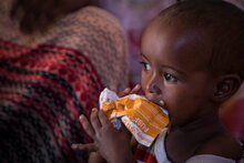 WFP/Marco Frattini, Ein Kind verzehrt PlumpySub zur Behandlung mäßig akuter Mangelernährung (MAM) PlumpySup