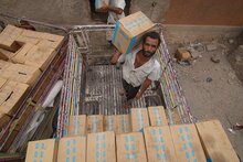 Workers stack food assistance in a warehouse in Lahj on 1 July 2019. Photo credit: WFP/Saleh Baholis