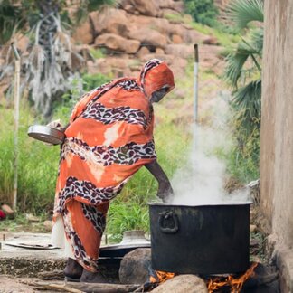 Frau beim Kochen mit angereicherten Nahrungsmitteln, die vom WFP als Reaktion auf akute Unterernährung im Sudan bereitgestellt wurden