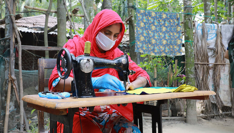 Während der Covid-19-Pandemie stellte WFP in Cox's Bazar, Bangladesch, im Rahmen seines Programms zur Sicherung des Lebensunterhalts gemeinsam mit Frauen aus der Aufnahmegesellschaft und Rohingya-Flüchtlingen Masken her, die von der örtlichen Regierung und humanitären Organisationen verteilt wurden. Sie erhielten ein monatliche Gehalt, eine Ausbildung in marktfähigen Berufen und finanziellem Wissen sowie ein Stipendium zur Gründung eines Unternehmens. WFP/Nalifa Mehelin