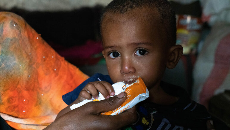 Jemen. Sultans Mutter füttert ihn zu Hause mit einer nahrhaften Erdnusspaste. Er leidet an Unterernährung. Dank der Zusatznahrung, die er von WFP erhält, hat Sultan begonnen, an Gewicht zuzunehmen und hat mehr Energie als zuvor. Aber er muss immer noch behandelt werden. Seine Familie erhält auch Nahrungsmittelhilfe vom WFP - Mehl, getrocknete Bohnen, Öl, Zucker und Salz. WFP/Mohammed Awadh